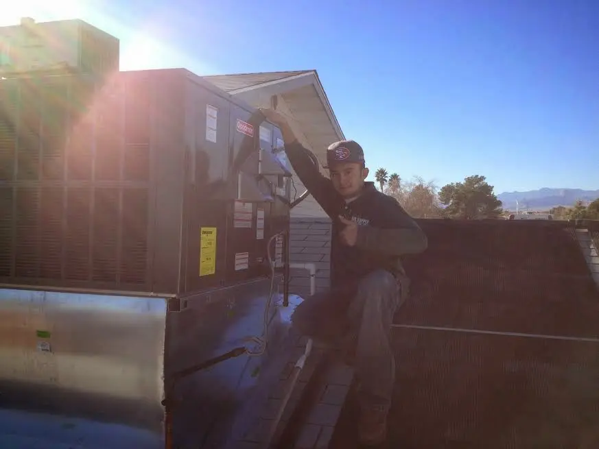 HVAC technician performing AC Tune-Up on a rooftop unit in New Rochelle